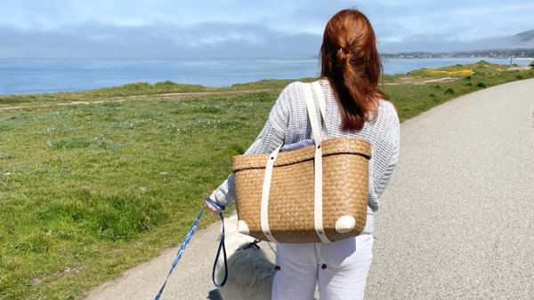 Women walking down a beach path carrying a seagrass beach summer bag