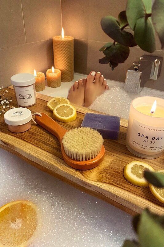 Women relaxing in a bath with candles and bath salts