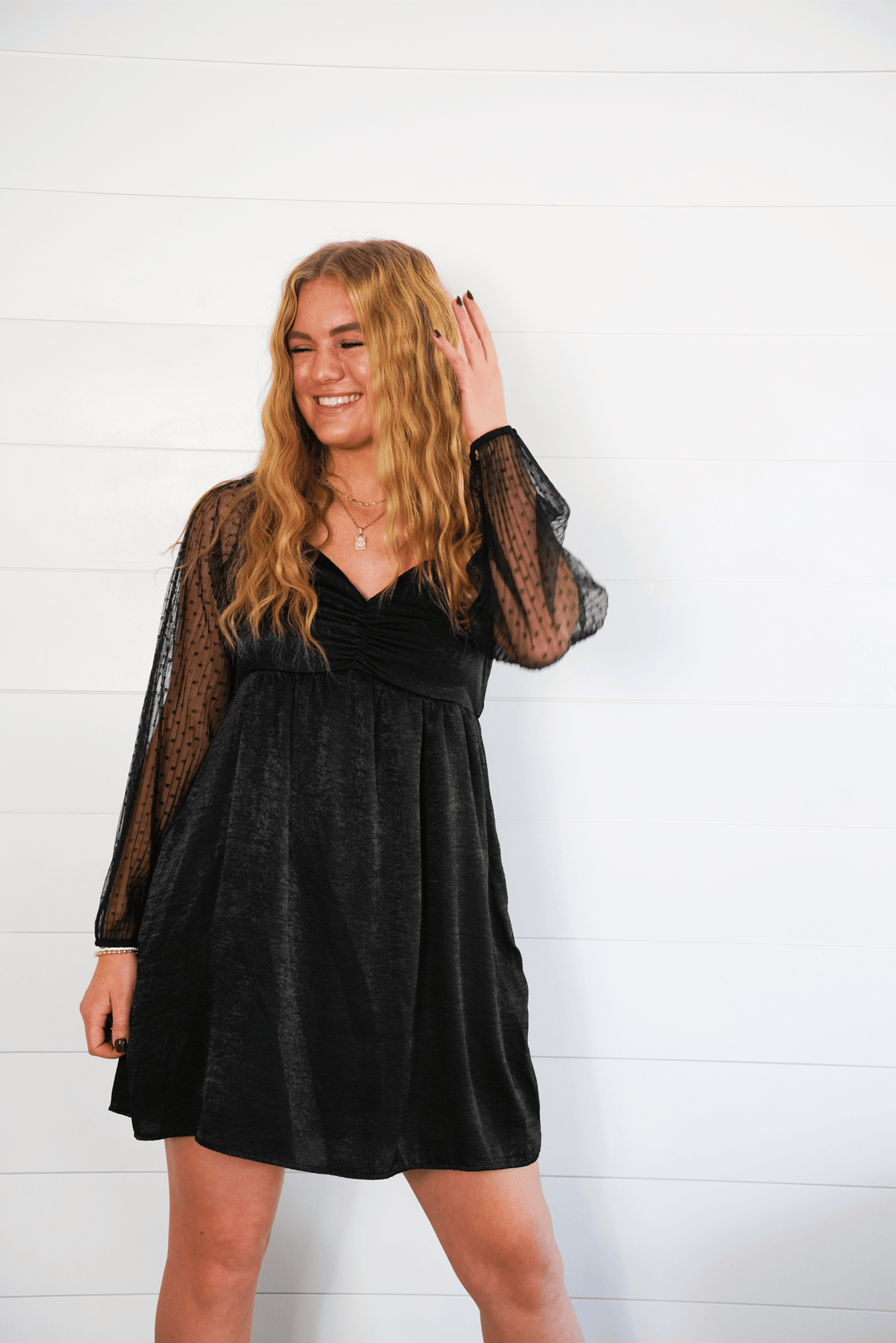 Women in black chiffon dress with lacy long sleeves
