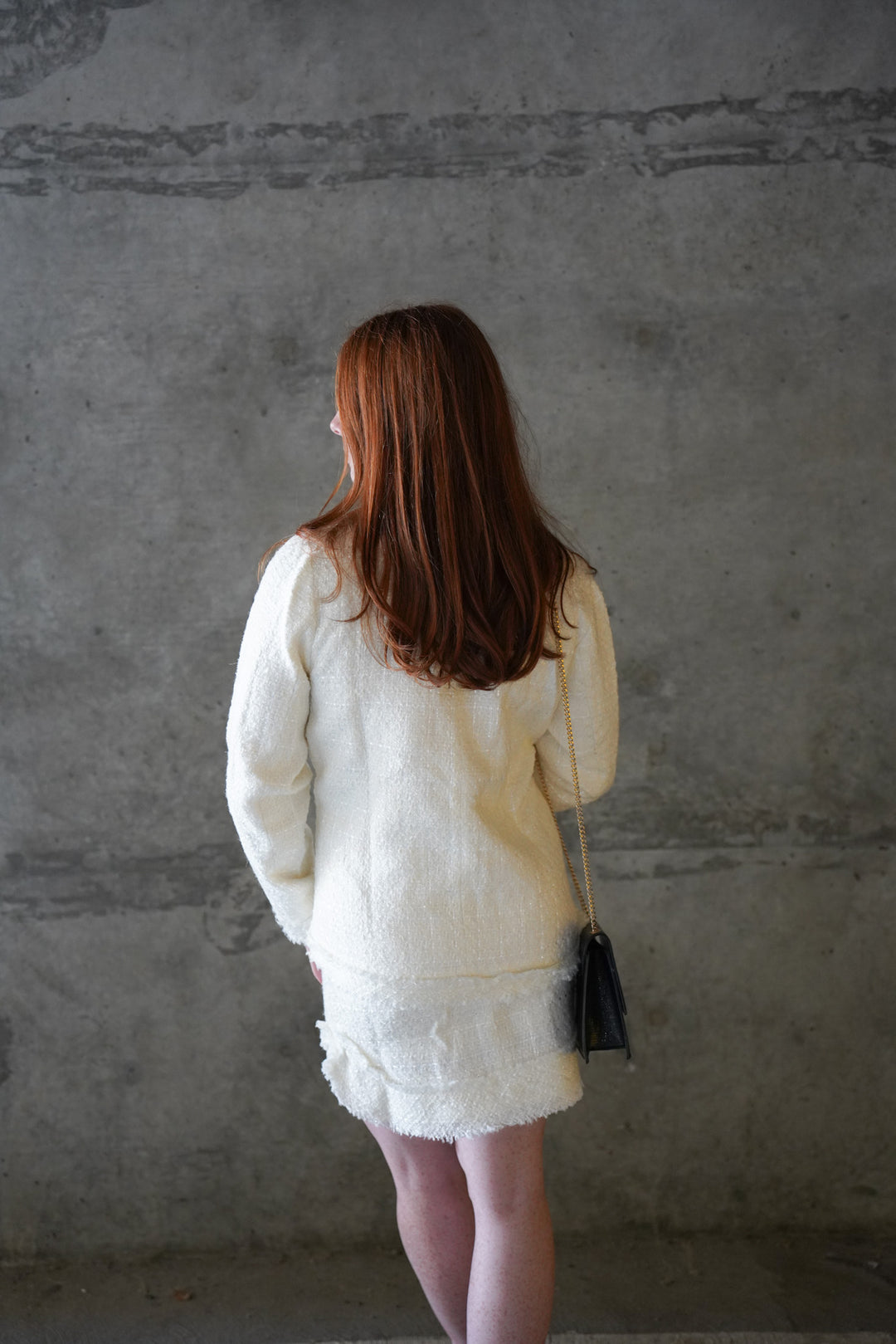 Women wearing white tweed jacket with pockets and gold buttons
