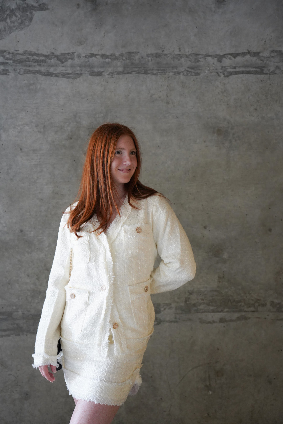 Women wearing white tweed jacket with pockets and gold buttons