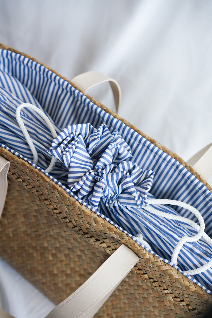 Drawstring Sedge Seagrass Basket tote bag with blue and white inner lining and faux leather handles