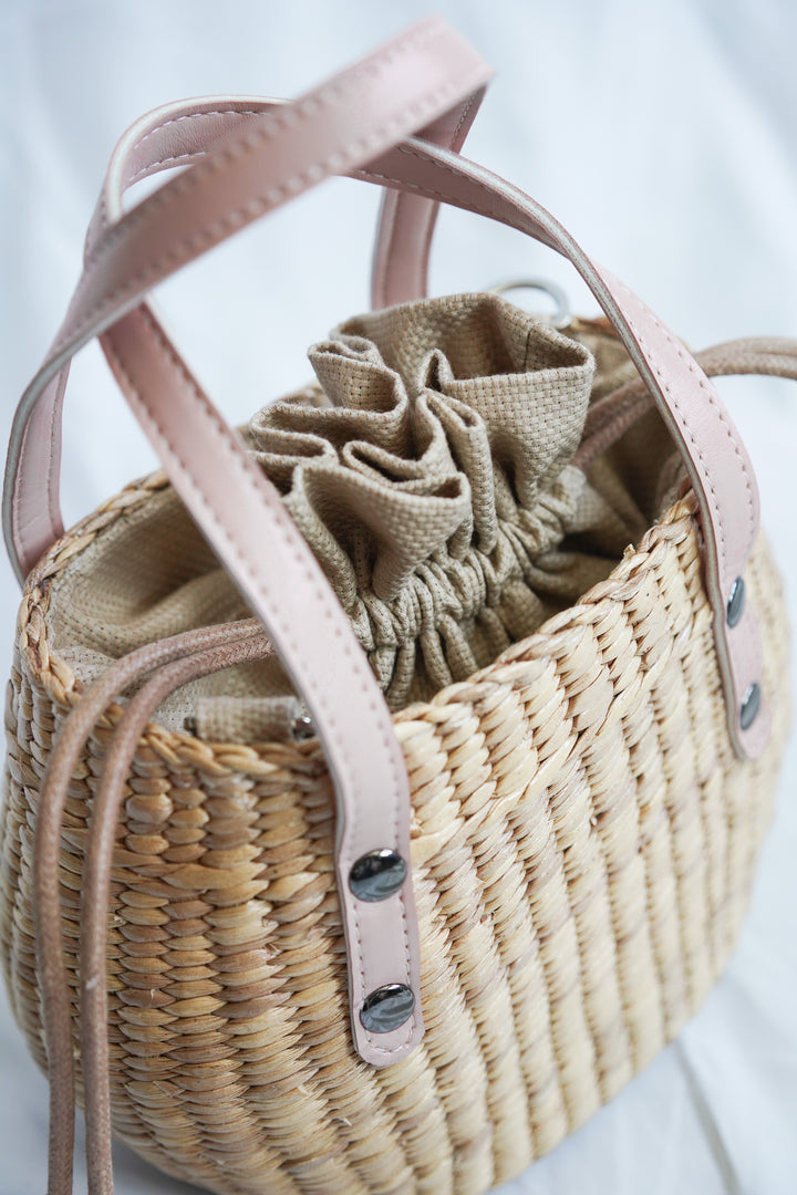 Handbag collection made from pliable sedge seagrass with pink faux leather handles