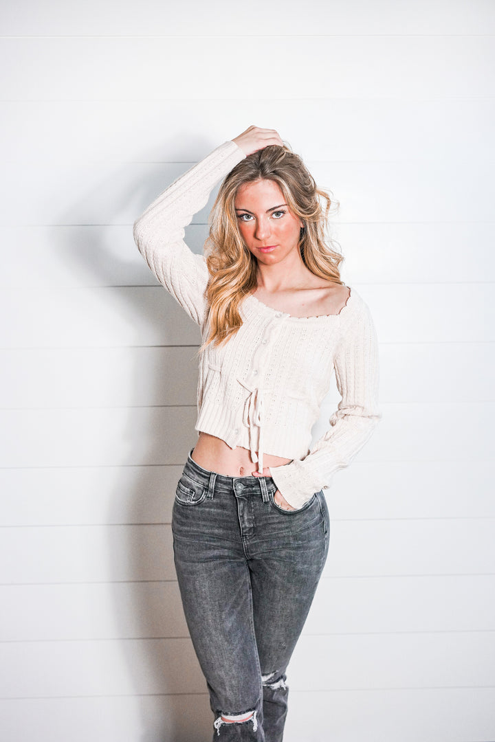 Casual Cropped Knit Top with neutral tones, scalloped neckline, button front closure, and tie waist
