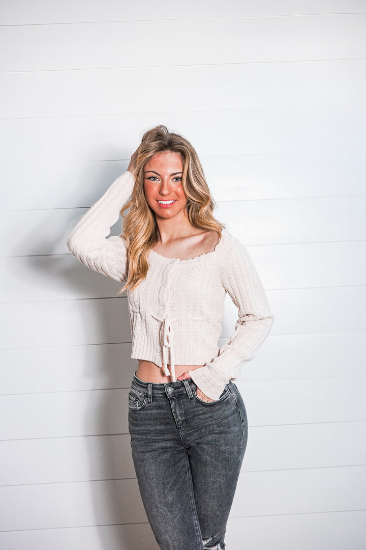 Casual Cropped Knit Top with neutral tones, scalloped neckline, button front closure, and tie waist