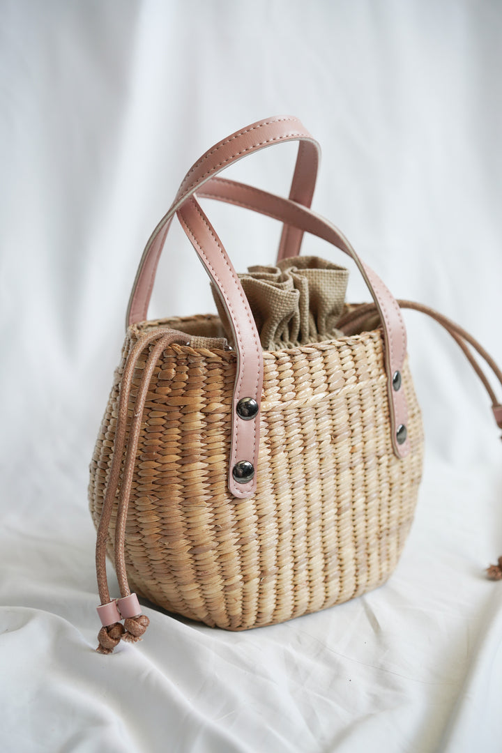 Handbag collection made from pliable sedge seagrass with pink faux leather handles