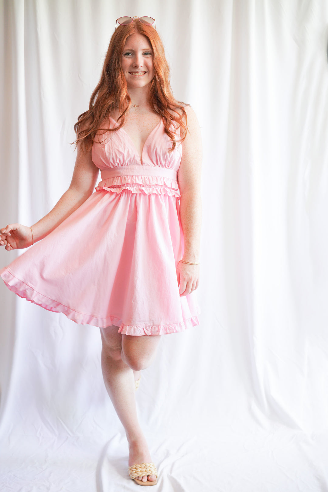 Pink sundress with deep v-neck opening and ruffle hem detail is made with 100% cotton