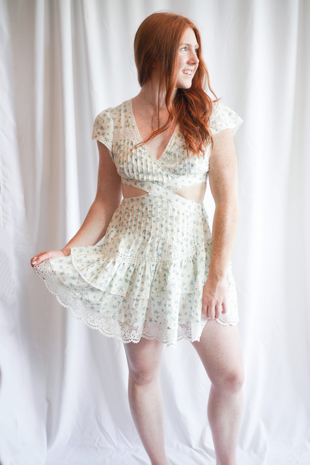 mini dress with lace crochet trim and floral print, flutter sleeves, and a waist side cut out