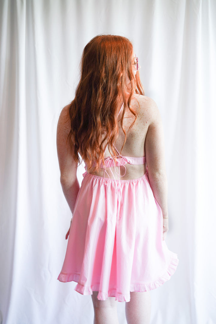 Pink sundress with deep v-neck opening and ruffle hem detail is made with 100% cotton