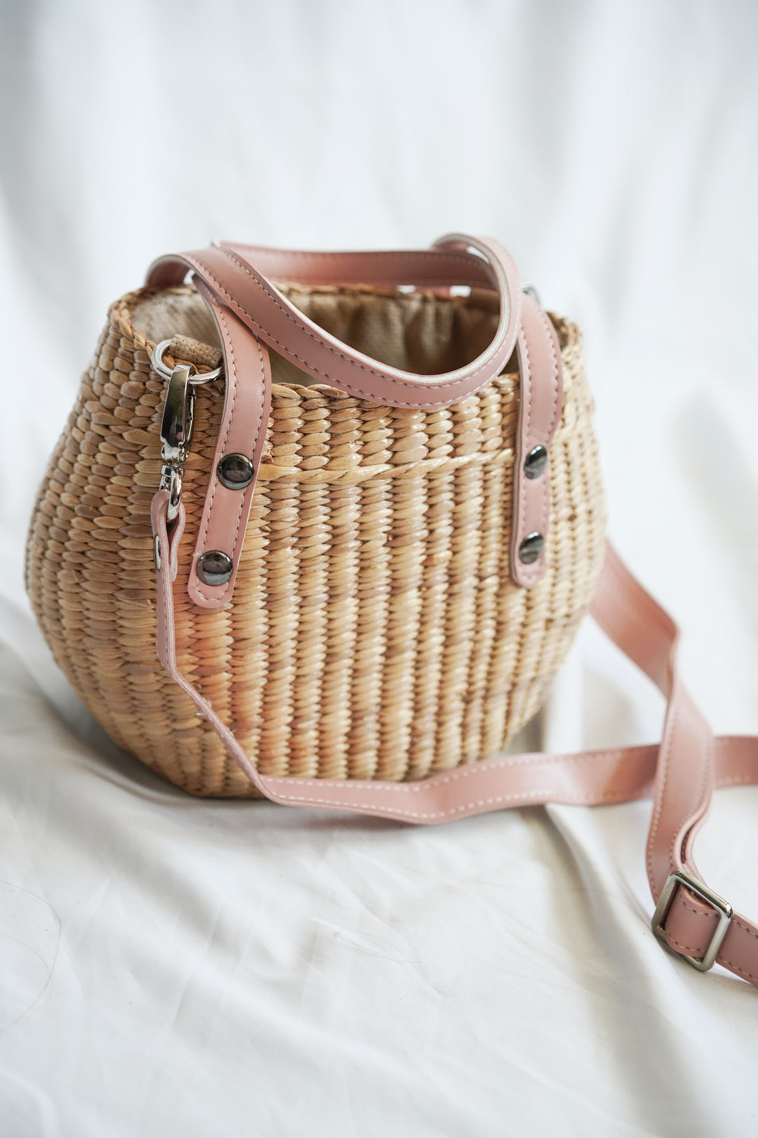 Handbag collection made from pliable sedge seagrass with pink faux leather handles 