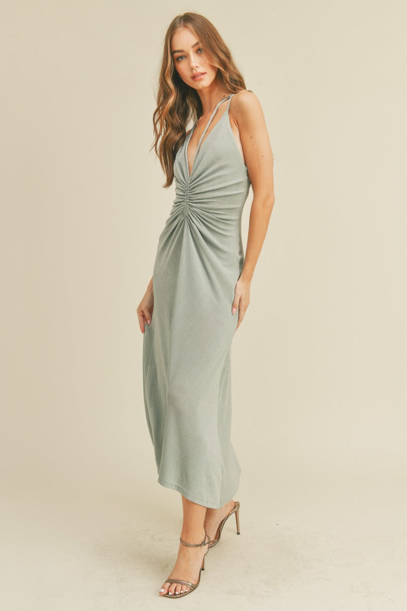 Ruched minty-grey halter dress with slinky fabric, deep v-neck detail, midi length and self tie open back detailing. 