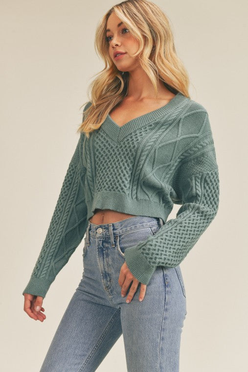  Sweater has a cutout back that ties, cable knit design, and beautiful teal color