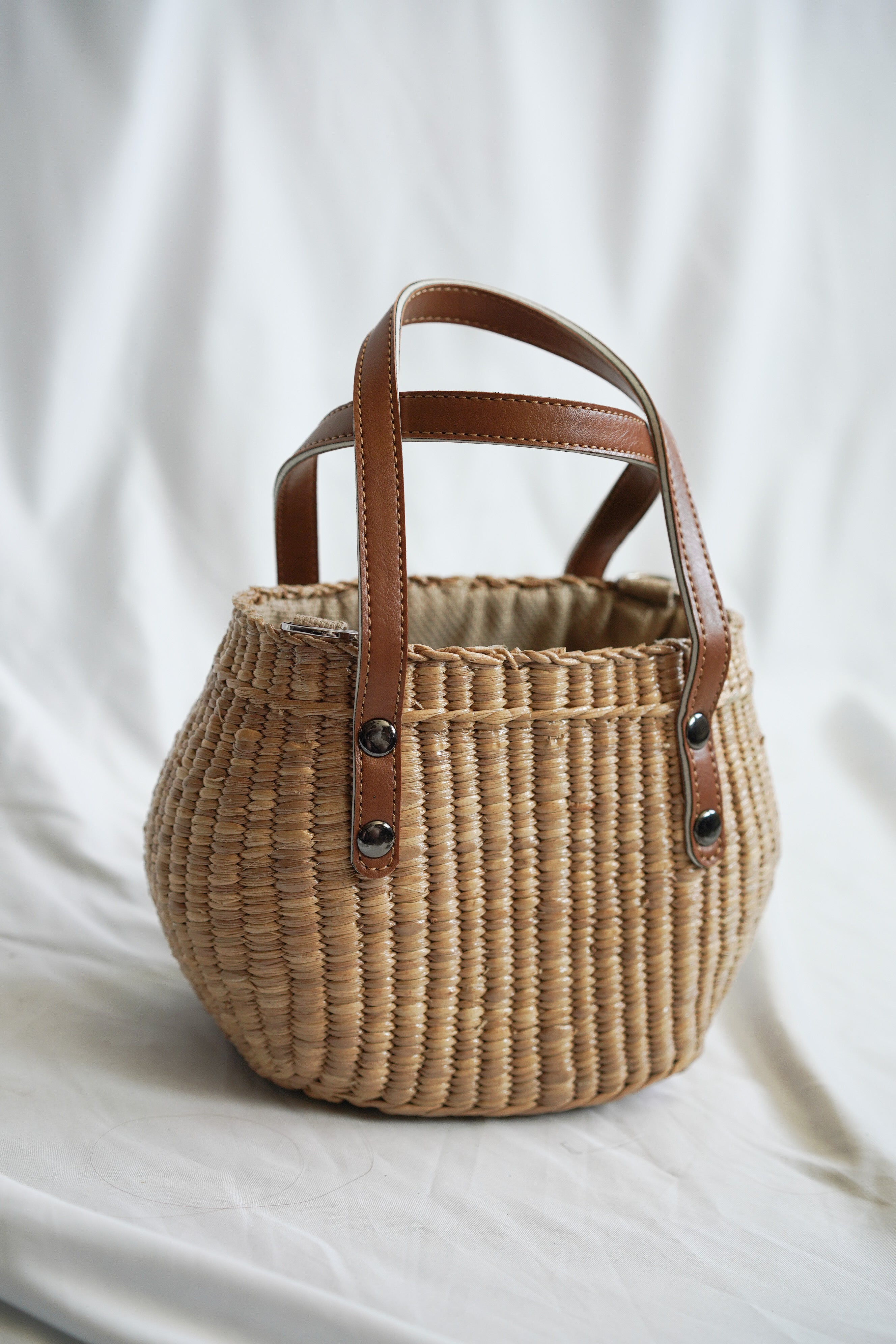 Handbag collection made from pliable sedge seagrass with faux leather handles and a convenient drawstring closure
