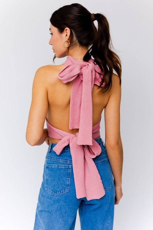 The back of this knit crop top ties around the neck and around the waist. It is a rose pink color and can be worn in many different ways. 